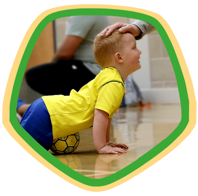 Toddler crawling next to SOCATOTS football